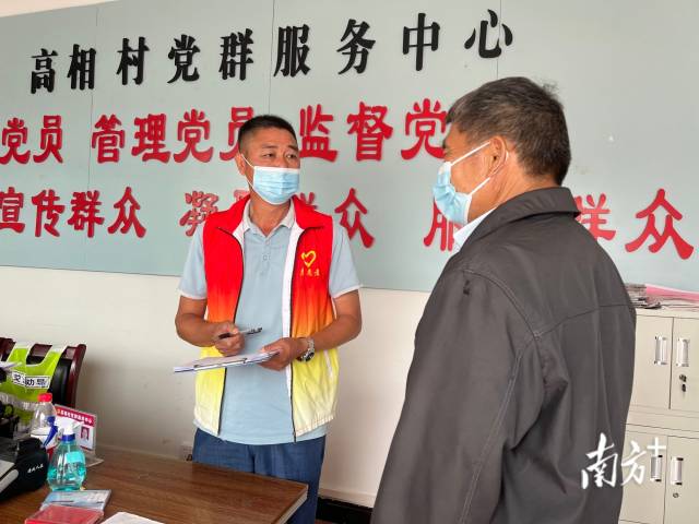 正在為群眾辦事的沈家江（左）。
