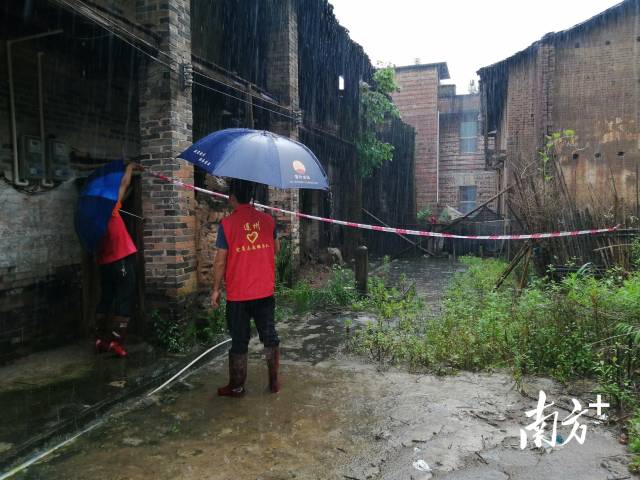 黨群志愿者冒雨拉起警戒線。