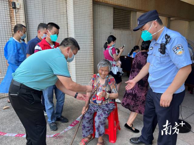 連州市委常委、副市長、九陂鎮(zhèn)黨委書記綦鴻偉在核酸檢測現(xiàn)場協(xié)助老人參加核酸檢測，為老人做好防暑措施。
